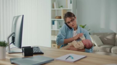 İş-Hayat Dengesi, Günlük Ebeveynlik, Hibrit Yaşam Tarzı. Modern Tarafsız Sahne 'de Profesyonel Bir Kadın Bebeğini Bir Şişeyle Beslerken Masasında Çalışıyor, Kariyer Görevlerini Dengelemekte ve Aile Bakımını Dengelemekte