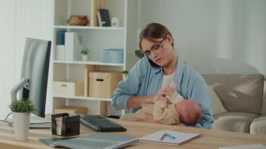 İş-Hayat Dengesi, Yanma, Duygusal Yükleme. Yorgun bir iş kadını bebeğini beslerken telefonda konuşur ve ofis işlerini yürütür. Gerçekçi Stres, Ebeveynlik ve Kariyer Baskısı Sahnesi