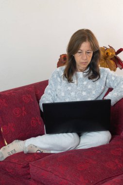 Yetişkin bir kadın hapisteyken evinin oturma odasındaki bilgisayarı kullanıyor.