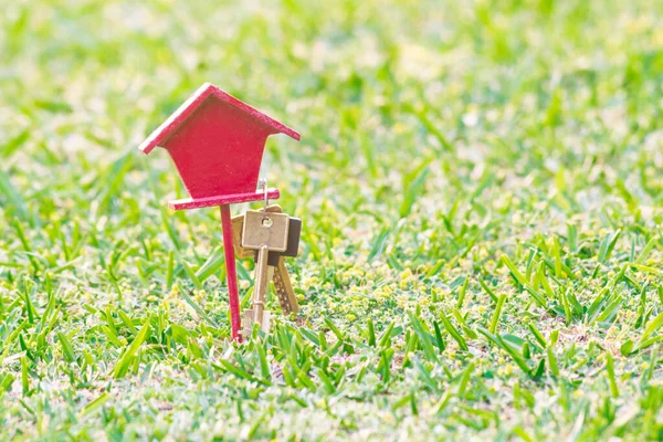 little house with keys hanging on grass background