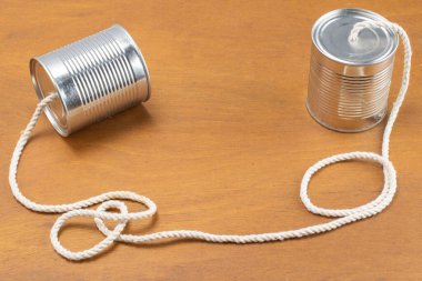 Konserveler ahşap arka planda bir telefon olarak kabloyla birleşir