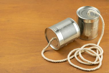 Konserveler ahşap arka planda bir telefon olarak kabloyla birleşir