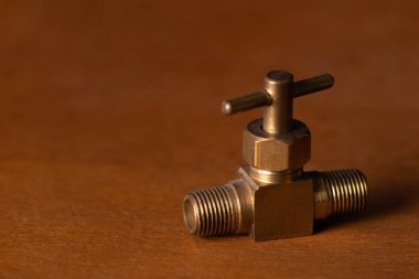 Tahta masadaki küçük bronz gaz vanası.