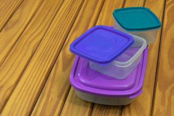 Hermetic plastic food containers on wooden base