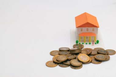 Önünde bir sürü bozuk para ve sağa yazacak yer olan minyatür bir ev.