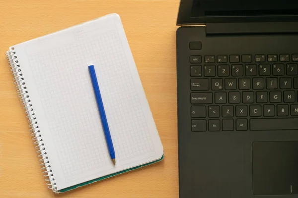 Laptop , blank notebook and cheap ballpoint pen