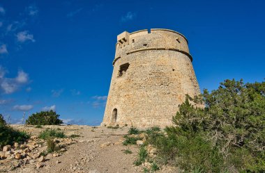 IBIZA, İSPAIN, Mart 2021, İspanyol adası kıyısındaki yuvarlak taş kule savunma duvarı.