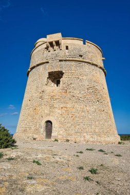 IBIZA, İSPAIN, Mart 2021, İspanyol adası kıyısındaki yuvarlak taş kule savunma duvarı.