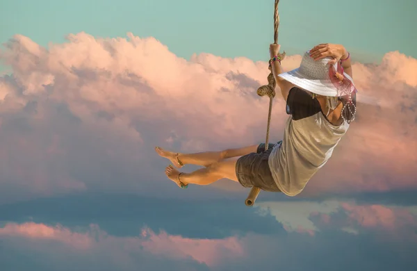 Frau schwingt in den Wolken — Stockfoto