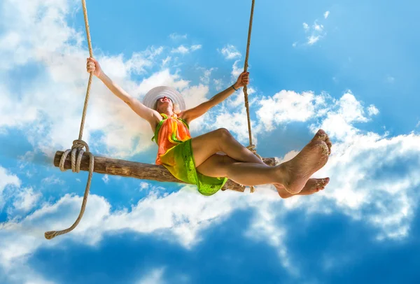 Frau schwingt in blauem Himmel — Stockfoto