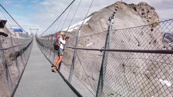 Woman photographer on Titlis mount bridge — Stock Video