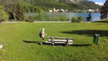 St. Moritz bankında sırt çantalı bir kadın.