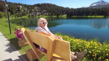 Arosa bankında sırt çantalı bir kadın