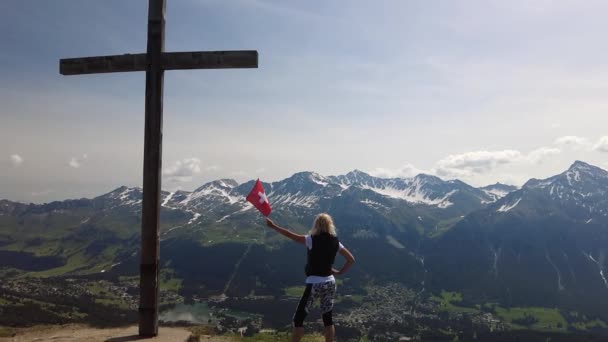 Kvinna ovanpå Piz Scalottas schweiziska flagga — Stockvideo