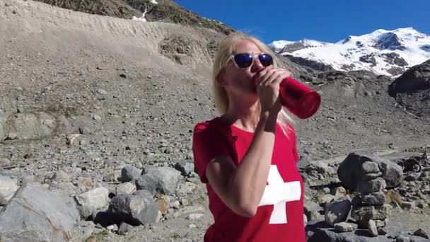 Γυναίκα πόσιμο νερό από Morteratsch παγετώνα — Αρχείο Βίντεο