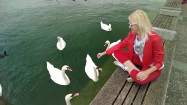 Zürih gölünde kuğulu bir kadın.