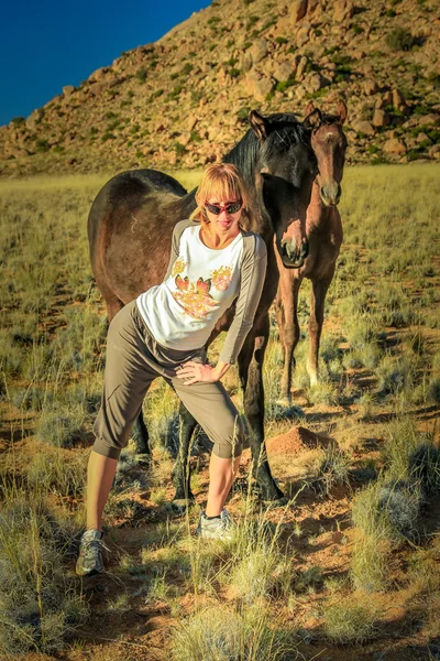Vrouw en wilde paarden — Stockfoto
