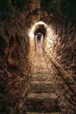 Romanya 'nın Transilvanya kentindeki popüler bir turizm merkezi olan tarihi Bran Şatosu' nun derinliklerine inen kemerli tavanı ve ilkel basamakları olan karanlık, antik taş bir tünel.