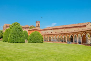 Ferrara 'nın Charterhouse' unda yükselen Aziz Christopher Kilisesi 'nin parlak mavi gökyüzünün altında parlayan ılık tuğla cephesi İtalya' nın Ferrara şehrinde huzurlu bir mimari güzellik manzarası yaratır.