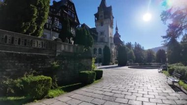 Sinaia 'daki Peles Kalesi, Neo-Rönesans kraliyet sarayı yemyeşil bahçeler ve parlak mavi gökyüzünün altında bir taş avlu, ikonik Romen mirası ve seyahat simgesi