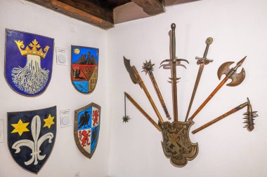 Transilvanya, Romanya, 12 Ağustos 2025: Tarihi ortaçağ silahları ve kraliyet kalkanları Romanya 'nın Bran Şatosu' nun iç duvarını göstererek antik Transilvanya mirasını gösterdi