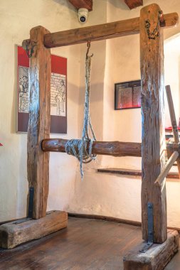 Transilvanya, Romanya, 12 Ağustos 2025: Romanya 'nın Transilvanya kentindeki Bran Drakula Kalesi işkence odasında ortaçağ ahşap vinci. Aracın işçiliğini ve tarihsel önemini vurgulamak