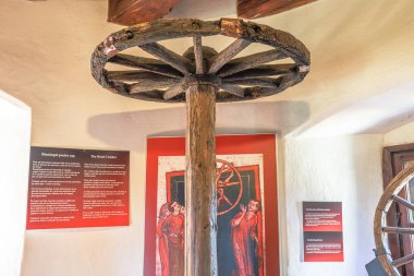 Transilvanya, Romanya, Aug 12,2025: Romanya 'nın Transilvanya kentindeki Bran Drakula Kalesi' nin işkence odasındaki tahtadan tavanın altında eski ahşap kırma çarkı, ortaçağ işkence aleti