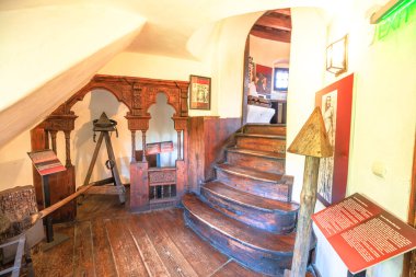 Transilvanya, Romanya, 12 Ağustos 2025: Bran Kalesi işkence odasında zincirli demir kemer ve üçgen ahşap destek, ortaçağ işkence ve acı ve ceza temalarını temsil ediyor