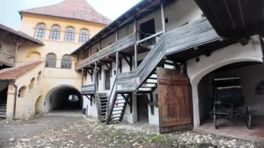 Romanya 'nın Transilvanya kentindeki Prejmer kilisesinin tarihi avlusu, ortaçağ savunma duvarları, kemerli giriş ve kaldırımlı evler gösteriyor. UNESCO 'nun Romanya sahası