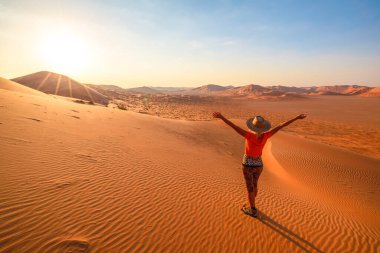 Şafakta Umman 'daki Boş Çeyrek Kum tepelerine tırmanan bir kadın..