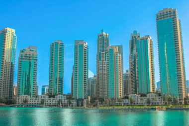 Canlı Burj Gölü kıyısı boyunca uzanan cam cepheli modern gökdelenler hızla gelişen şehir altyapısını ve Birleşik Arap Emirlikleri 'nde lüks bir seyahat merkezini tasvir ediyor.