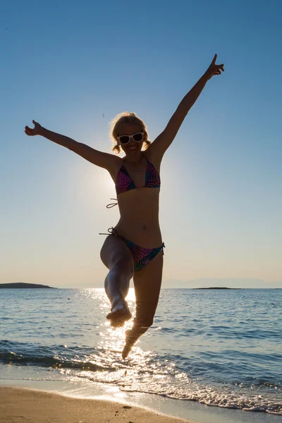 Frau springt an den Strand — Stockfoto