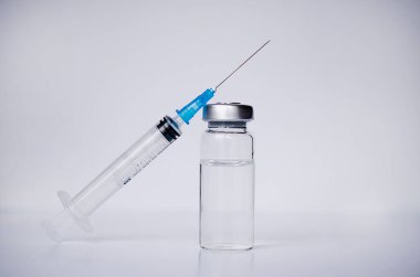 Ampuller ve şırınga ile Covid-19 aşısı bir laboratuvar masasında. Koronavirüs enfeksiyonunun önlenmesi, aşılanması ve tedavisi için. Bulaşıcı tıp konsepti. Kopyalama alanı ile