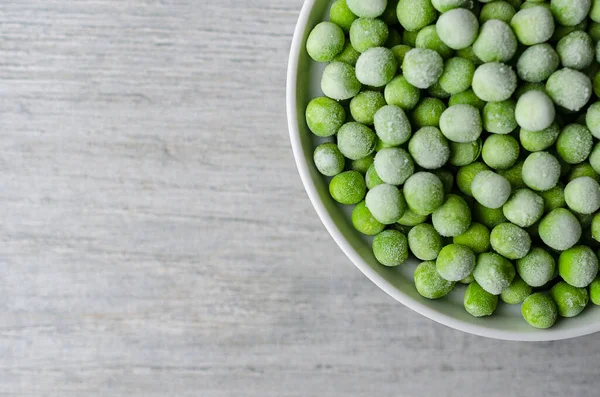 Verse bevroren erwten in een witte kom. met kopieerruimte — Stockfoto