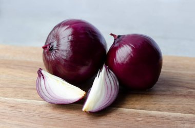 Gri arka planda mor soğan sebzesi yakın plan.