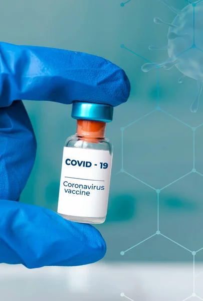 Ампули в руці і шприц з вакциною від Covid-19 на лабораторному столі. Для профілактики, імунізації та лікування коронавірусної інфекції. крупним планом — стокове фото