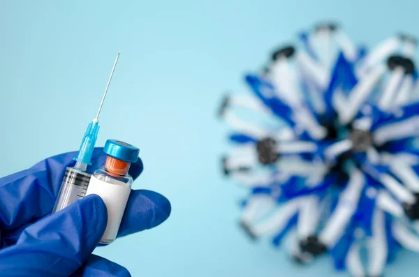 Ампули в руці і шприц з вакциною від Covid-19 на лабораторному столі. Для профілактики, імунізації та лікування коронавірусної інфекції. За допомогою простору копіювання — стокове фото