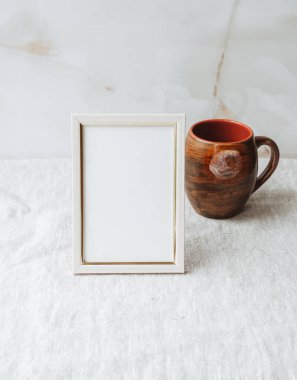 Masadaki boş fotoğraf çerçevesini düzenle. Gri keten masa örtüsü kumaş arka plan. Ev ofis dekorasyonu. Kopyalama alanı ile.