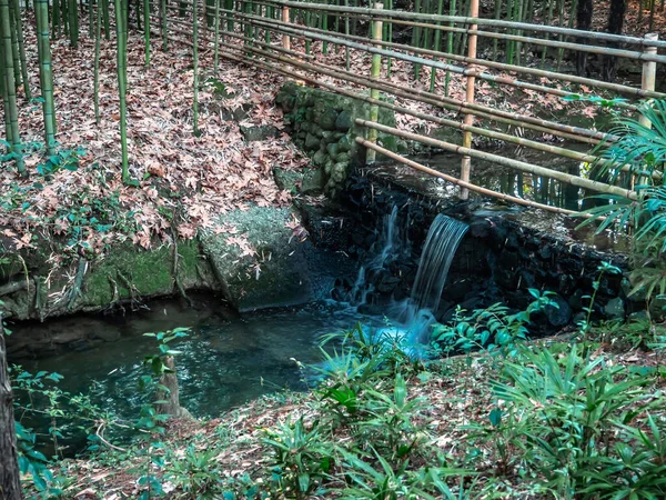 Japon tarzı çitleri olan küçük bir şelale.