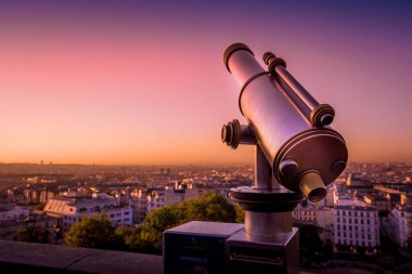 Paris, Fransa 'da canlı ve renkli bir gündoğumu sırasında Montmartre Hill' den çatıya bakan bir teleskop. Eylül 'de ılık bir sonbahar sabahı çekildi.