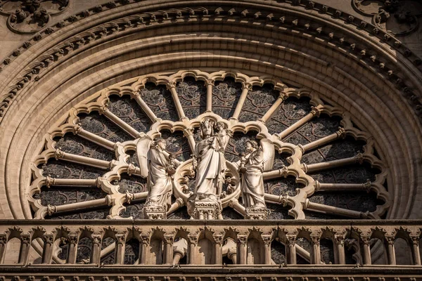The Virgin with Child statue and rose window on the west facade of Notre Dame Cathedral, Paris, France