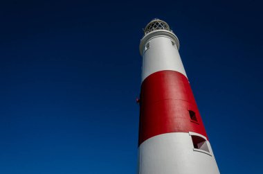 Portland Bill deniz fenerine baktığımızda, koyu mavi bir yaz gökyüzünün karşıtlığını görüyoruz, Portland Adası, Dorset, İngiltere