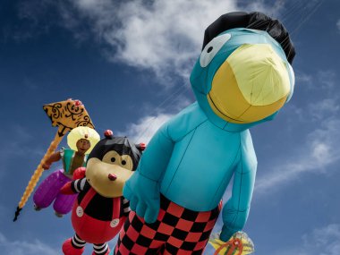 Yaz Southsea uçurtma festivalinde dev uçan karakter uçurtmaları, Portsmouth, İngiltere 'de mavi gökyüzü ve arka planda bulutlar