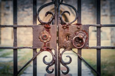 Kilisenin süslü, kilitli demir kapılarına eski ve paslı kilit