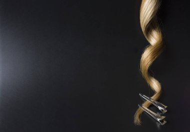 Strand Of Blond Curl Hair With Clips On The Edges On A Black Background,  Objects Vertical Placement clipart