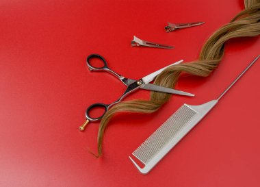 Kırmızı arka planda yapay kıvırcık saçlı, saç makaslarını aç. Profesyonel Makas, Gümüş Tarak ve Metal Makas