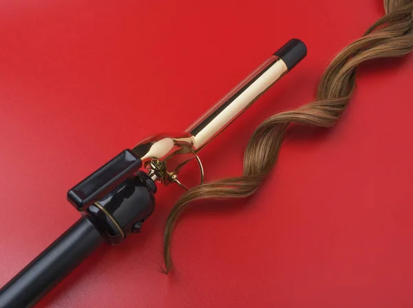 Professional Hairdressing Curling Iron Lock Waved Hair Red Background Spotted — Stock Photo, Image