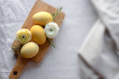 Tahtadaki sarı yumurtalar ve çiçekler. Kırsal paskalya arkaplanı.