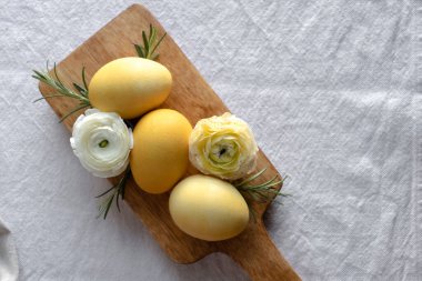 Tahtadaki sarı yumurtalar ve çiçekler. Kırsal paskalya arkaplanı.