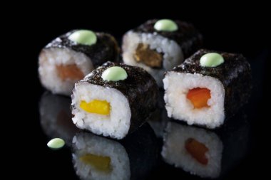 Siyah arka planda suşi yuvarlanıyor. Japon yemeği. Kapatın. Makro